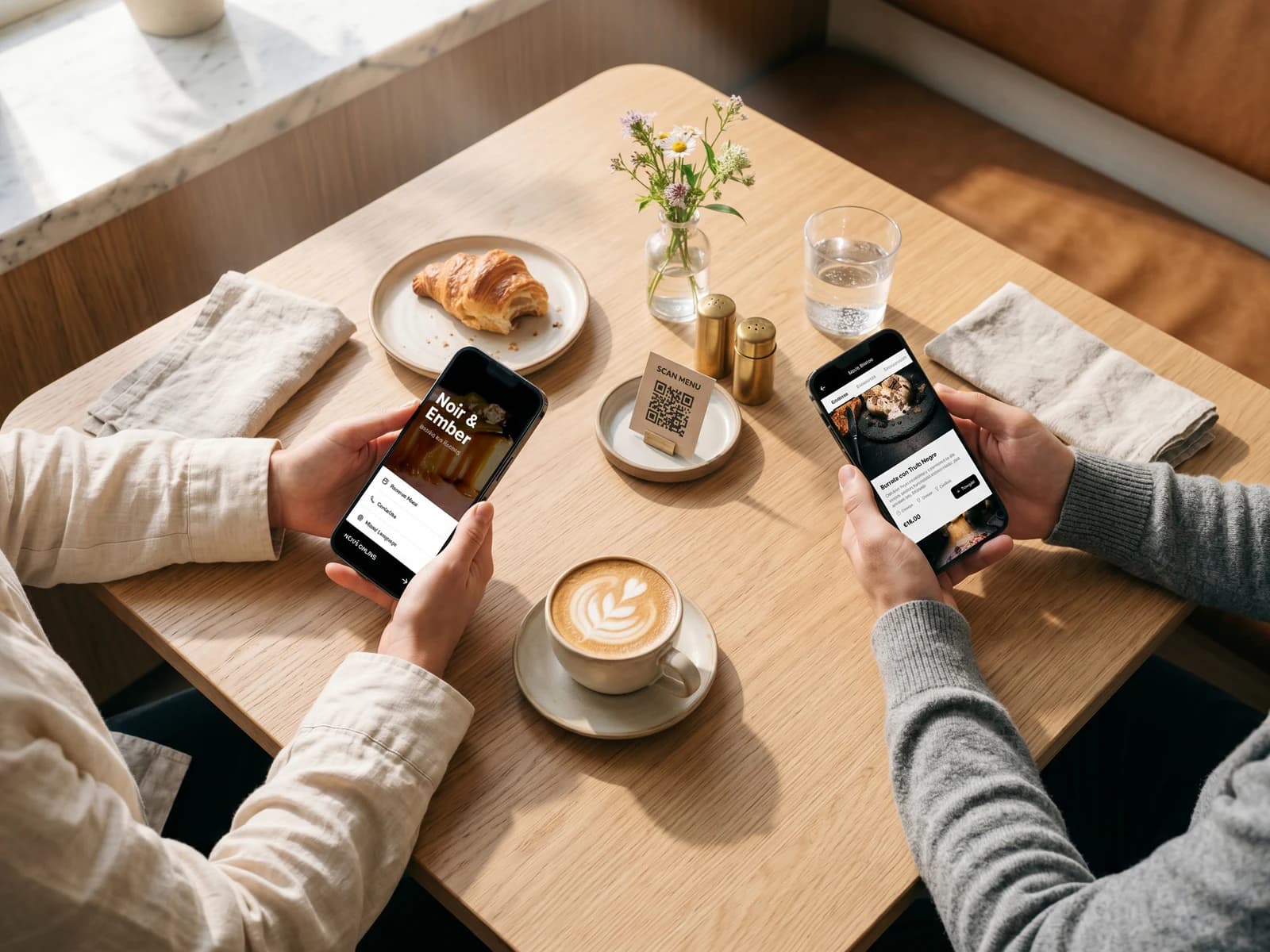 Two guests at a sunlit cafe table holding phones with the IQ Rest QR menu on screen